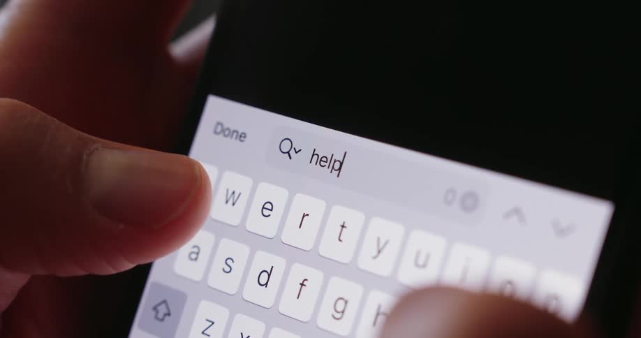 A person texts help on a phone