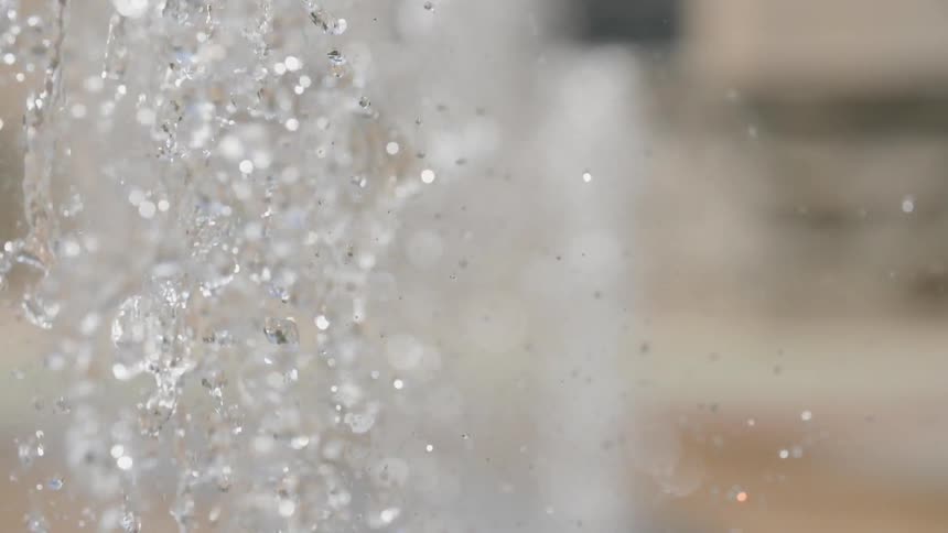 A water fountain shooting water up and a close up view of it