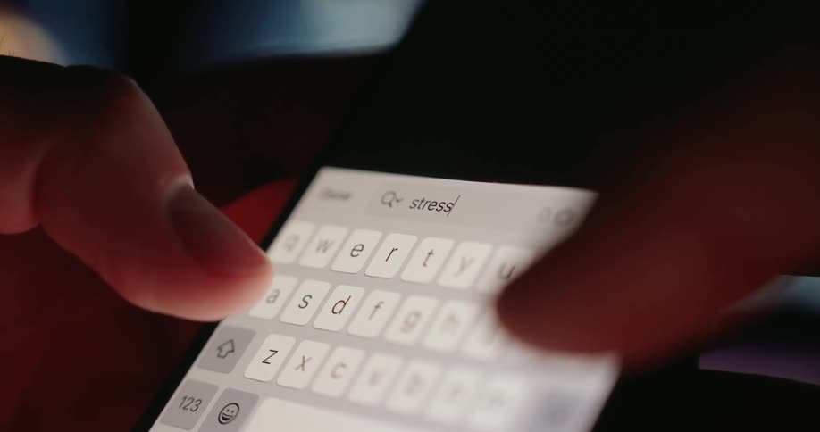 A person uses a lit up keyboard to send a text on a phone