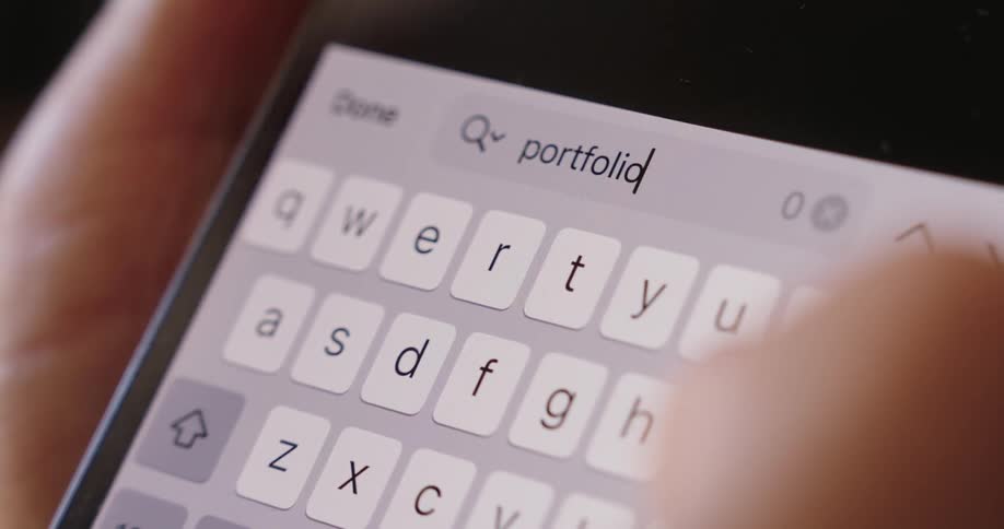 A person searches on his cell phone for the word portfolio