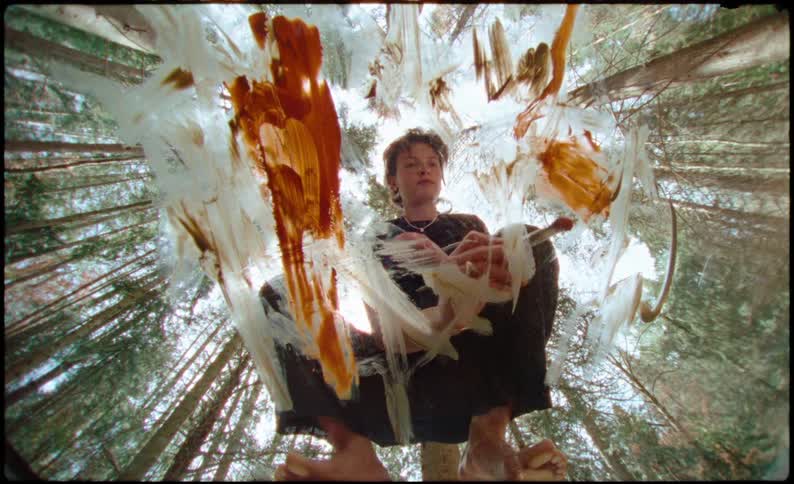 Woman painting a picture and a half of a forest