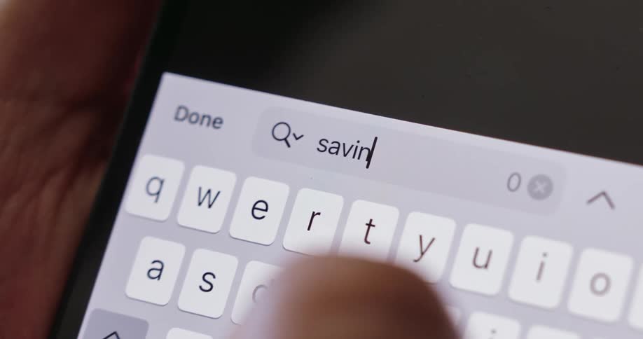 A person typing the word savings on their phone