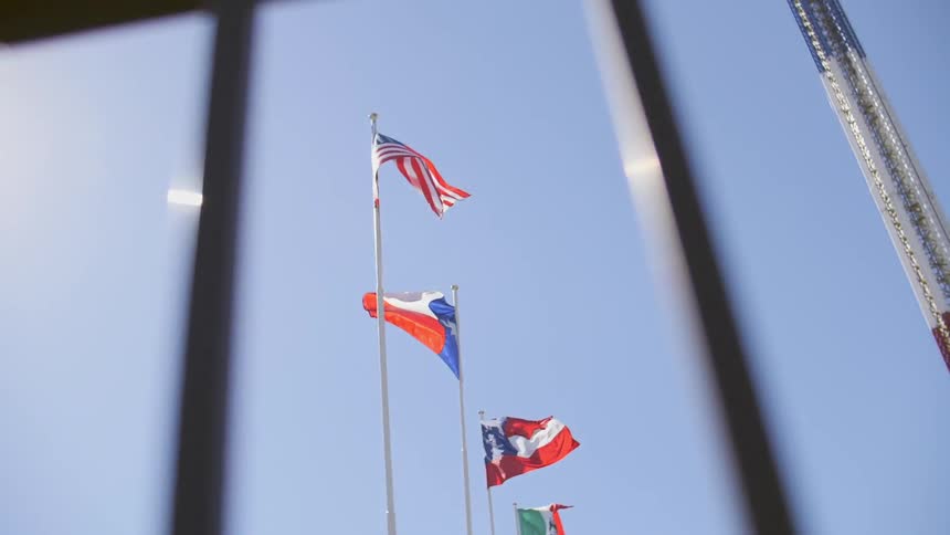 The clear sky is lined with flag poles