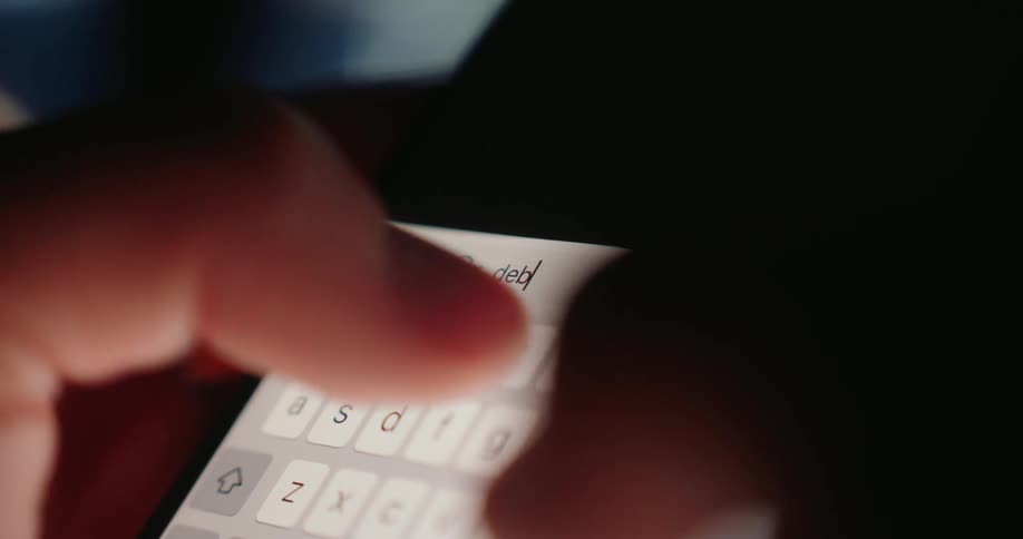 A persons finger types debt on a smartphone