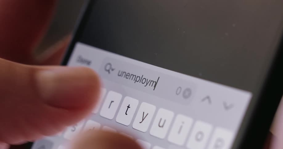 Fingers type on a brightly illuminated smartphone keyboard in a dimly lit area