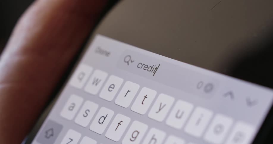 A person typing the word credit on their phone