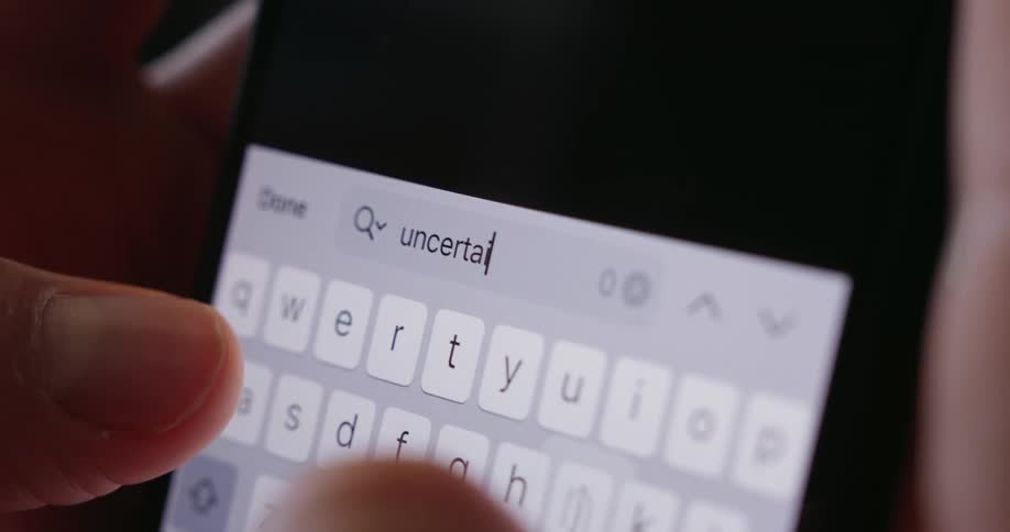 A person is typing on a cellphone with their thumbs