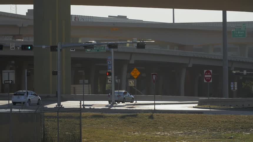 Cars driving on city street near freeway bridges