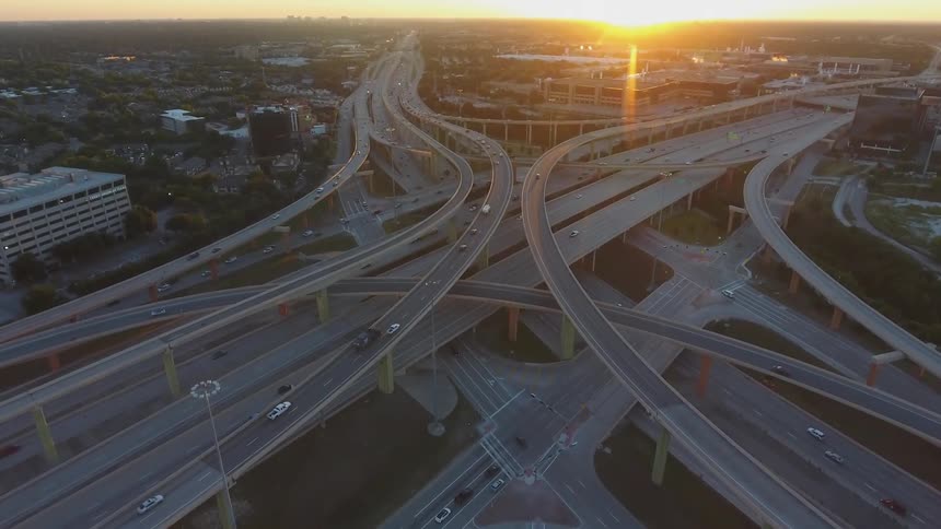 Cars driving over many overlapping and crossing city freeway bridges