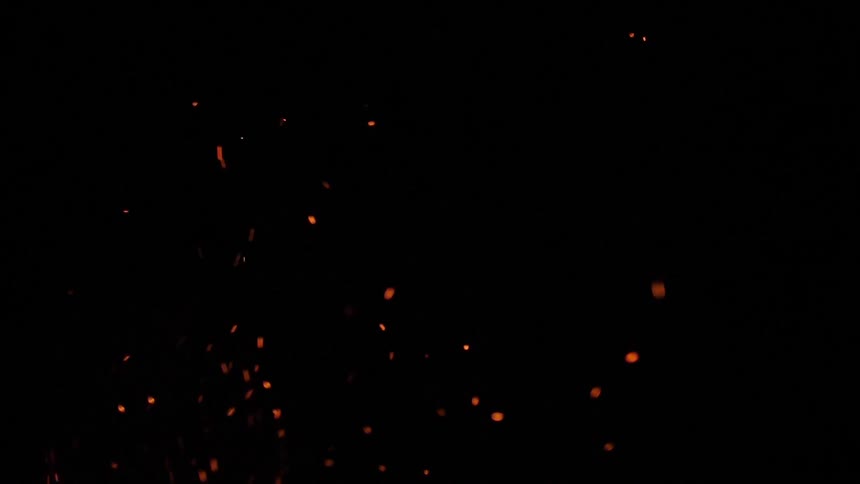 A fire is giving off small sparks in the night
