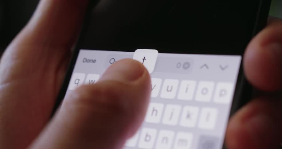 A closeup shot shows fingers typing the word debt into a search bar on a smartphone screen