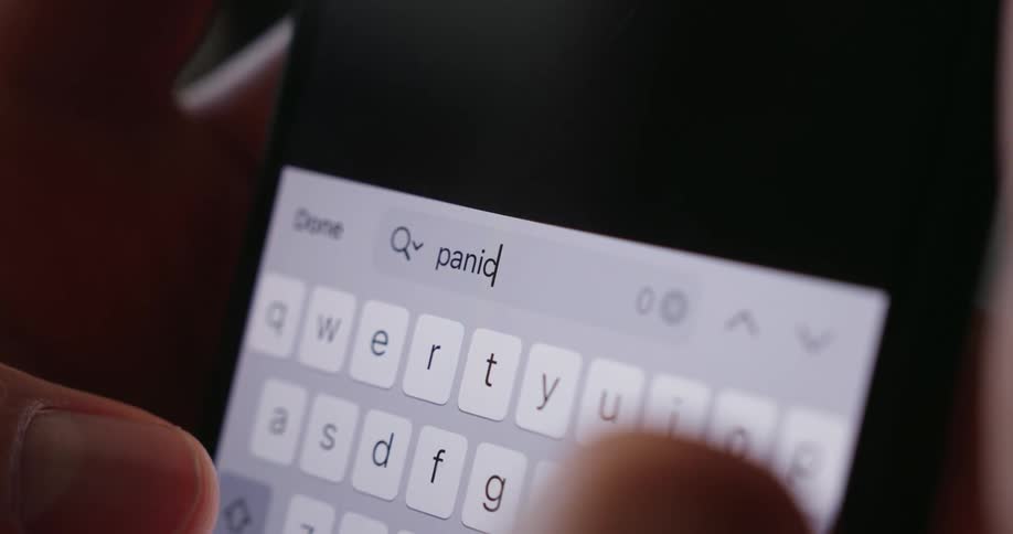 A person typing the word panic on a smartphone