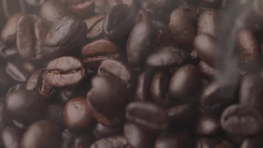 Coffee beans releasing steam vapors while roasting