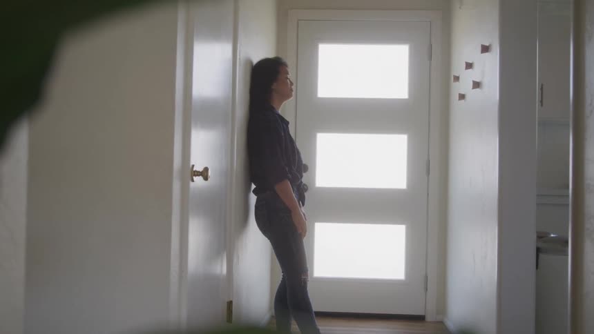 Sad woman walking back and forth and sitting in the hallway