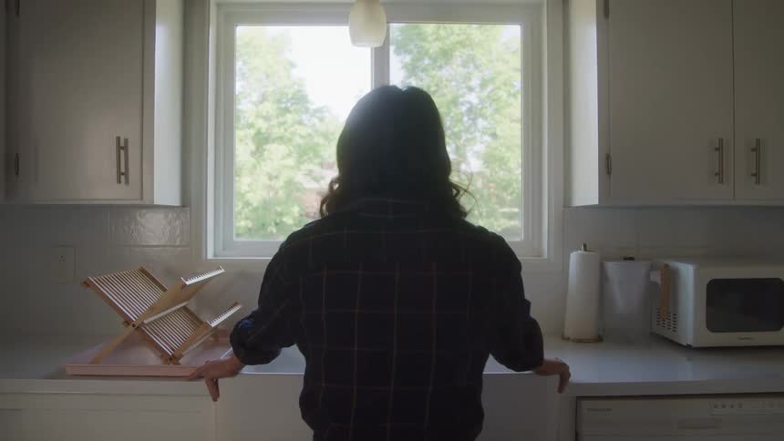 Back view of a woman at the kitchen sink