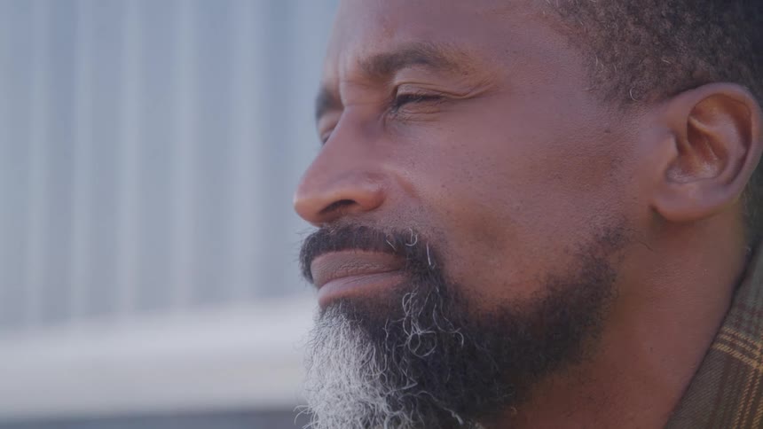 A man lifting his head and staring straight ahead deep in thought