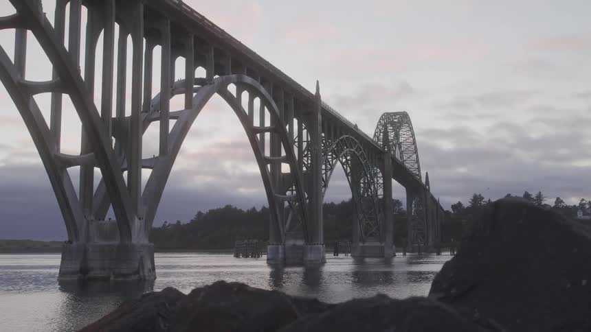 Boat heads towards an arched bridge on a cloudy day