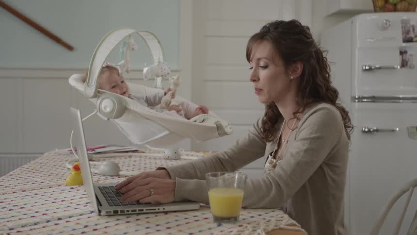A woman sitting next to a baby