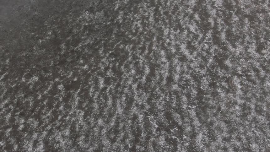 Aerial view of a ground covered with grass and snow