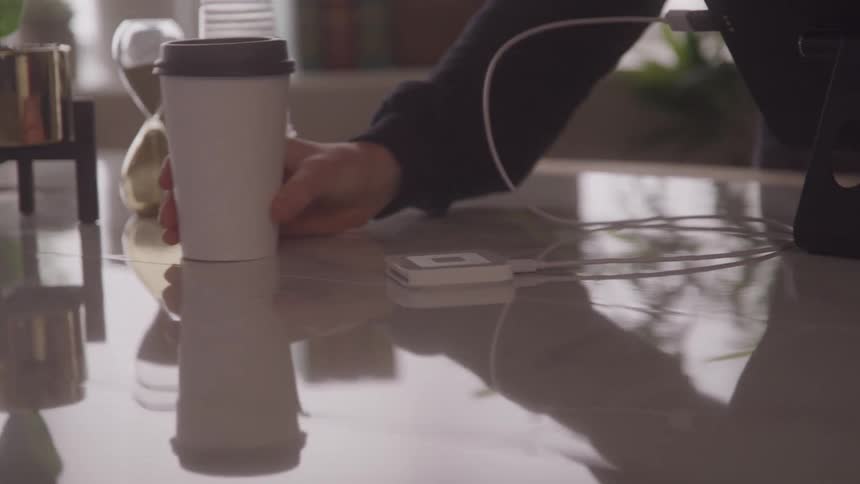 A person swiping a credit card on a payment device to buy an isolated coffee cup