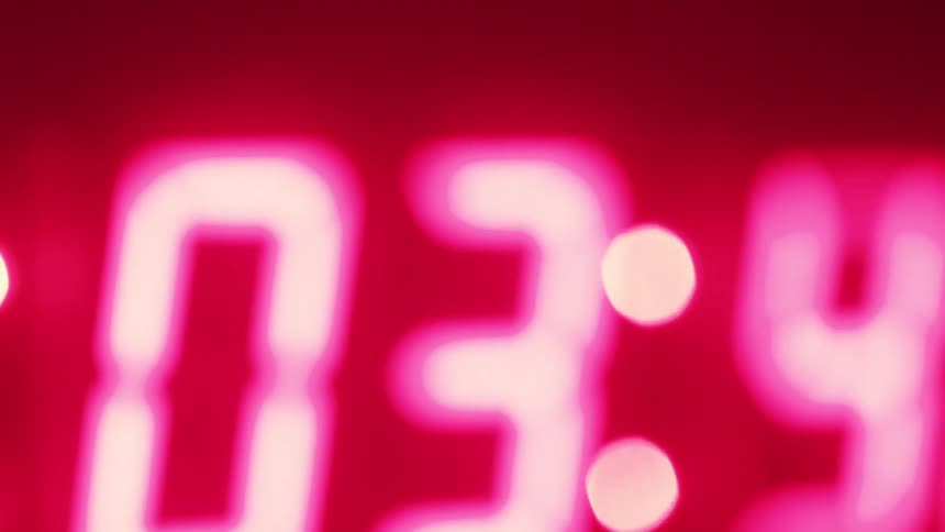 Close up of a clock with a neon red countdown display