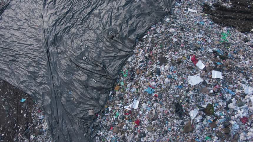 Aerial view of an openair dump with a black tarpaulin