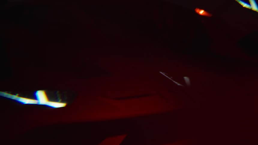 The sports car is in the dark with red light