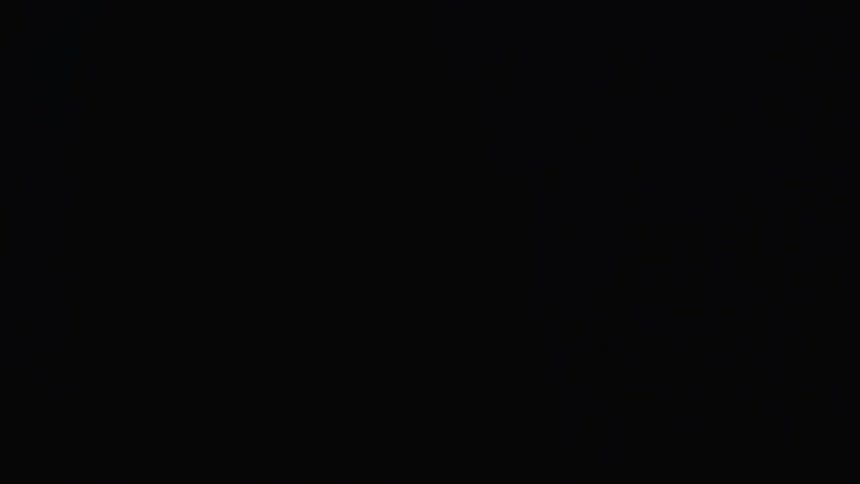 Blue lighting flashes and illuminates a staring man