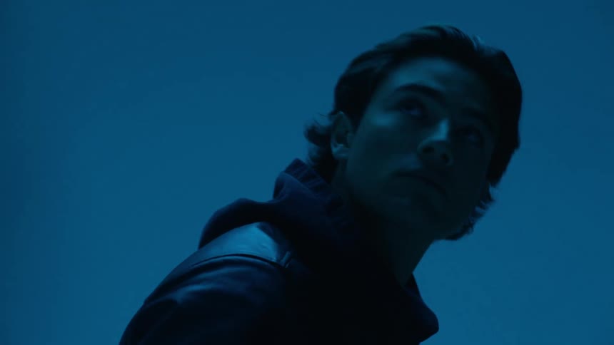 Portrait of a man in a leather jacket in a studio setting with dark lights