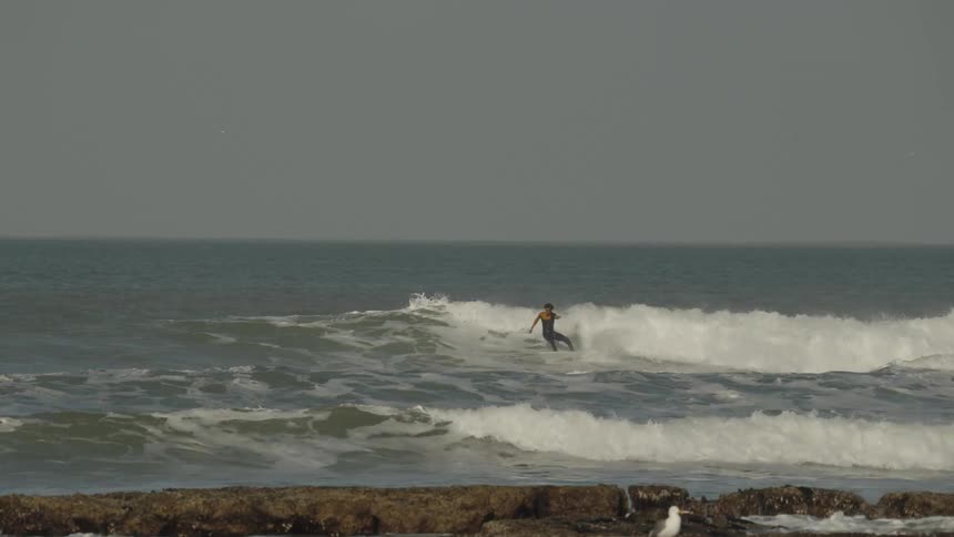 A man is surfing fast on the wave