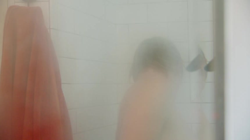 Foggy mirror reflects a person dancing while taking a shower