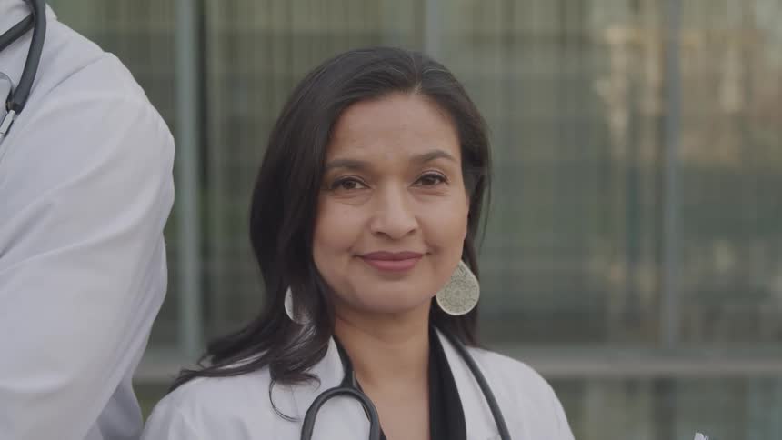 The female doctor smiles by the window outside