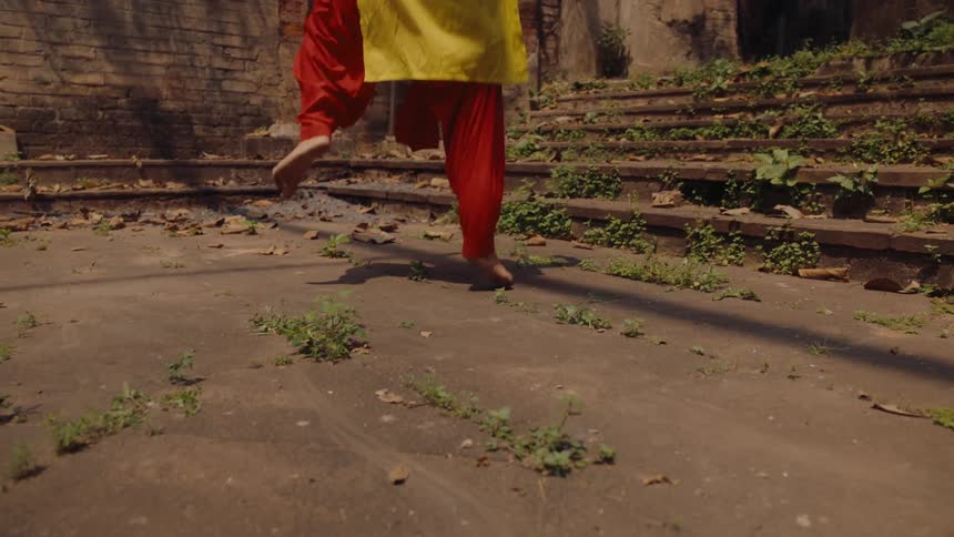 Women are dancing outside the ruins
