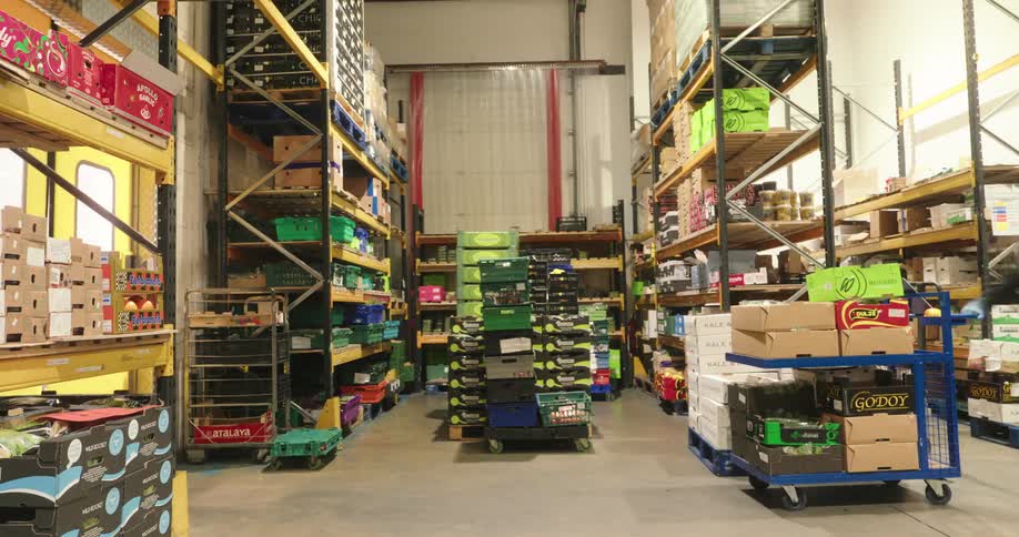 The workers carry boxes and move in the warehouse