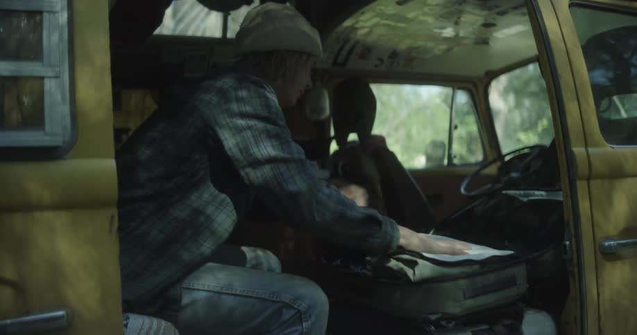 A man is packing luggage in the van