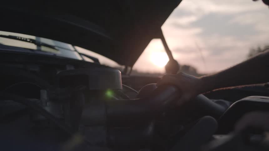 The mechanic is adjusting the hose on the vehicle engine