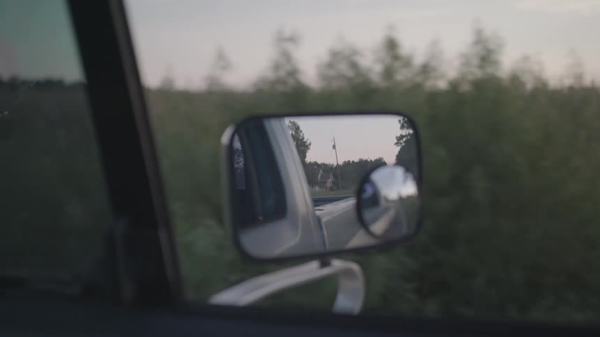 The pickup truck is driving past the tall grass