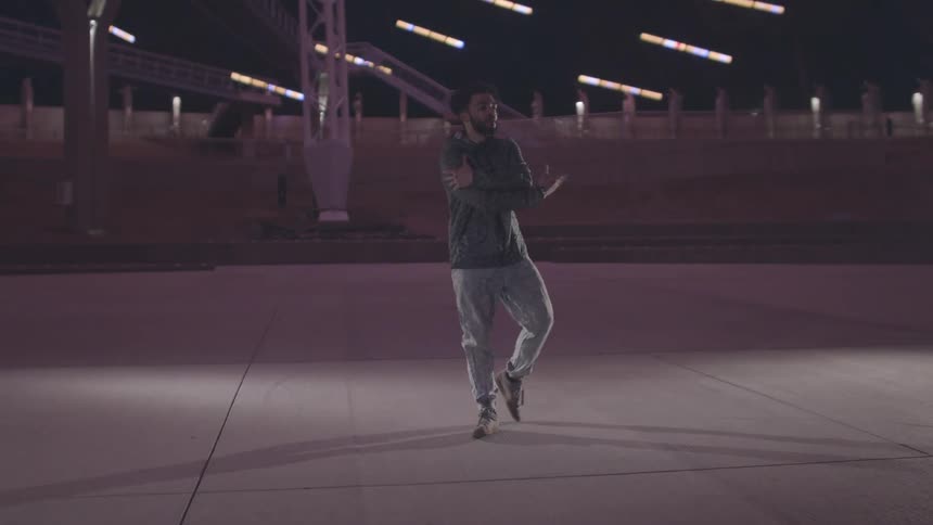 A man is inside a stadium dancing on the main floor