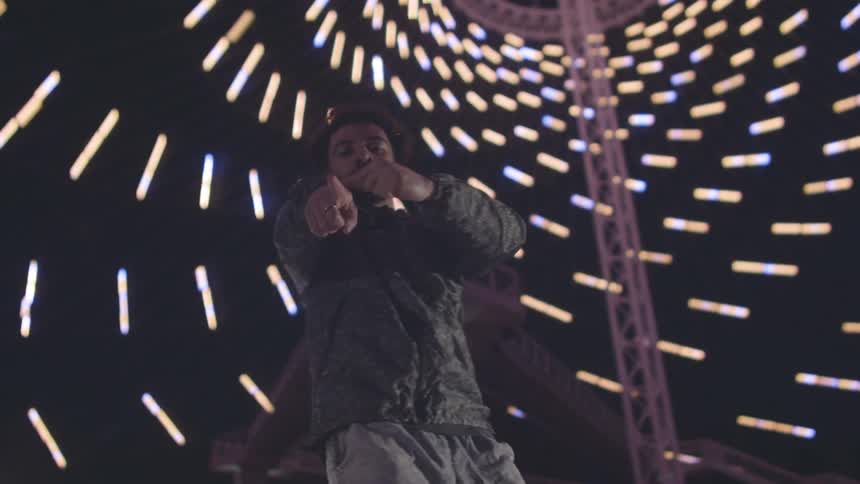 A man dances inside of a room with lights lining the walls
