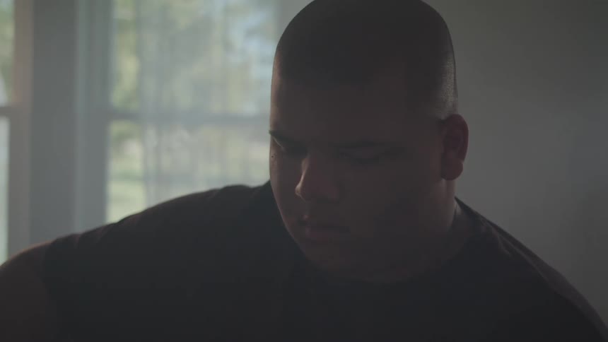 A young man moves his head around as if hes listening to or playing music