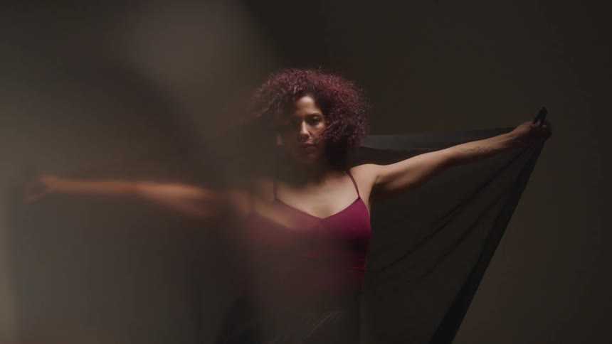 Woman model with open arms holding a black scarf