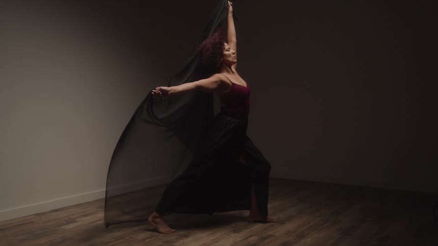 Woman posing with a black scarf in a studio lighting environment