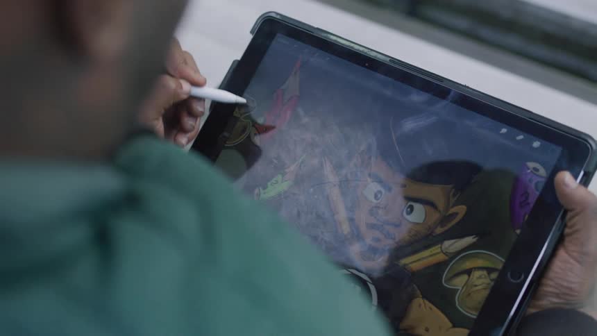 Person drawing and painting on a tablet
