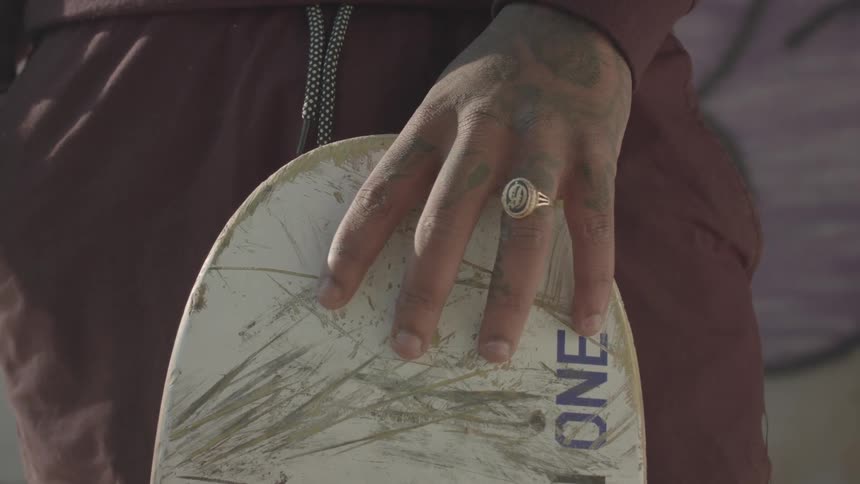 A man holding a skateboard in his hand