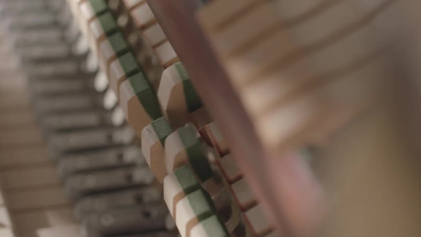Closeup of piano hammers in motion showing the instruments inner mechanics
