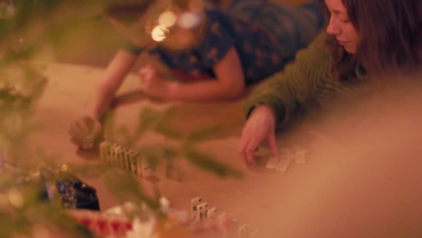 Mother and son stacking dominoes on the floor