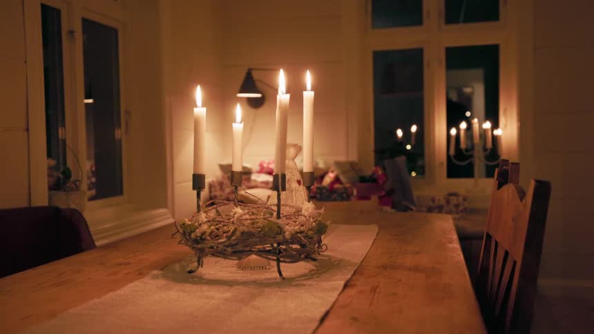 Candles are lit on the centerpiece on the dining table