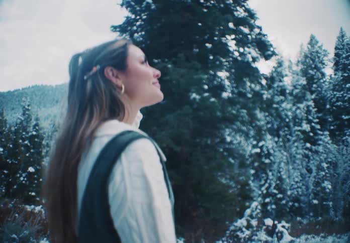 A woman is walking in the snow on the mountain