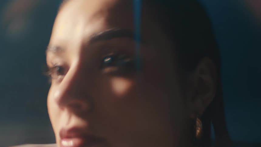 A woman is in a pool up to her neck in the dark