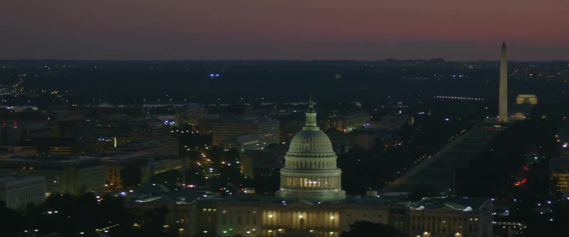 The tall buildings below are lit at dawn